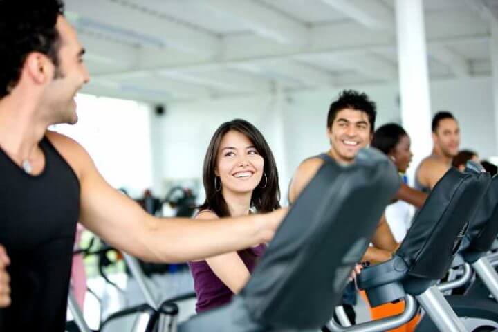 Los amigos de gimnasio hacen el entrenamiento corto y ameno