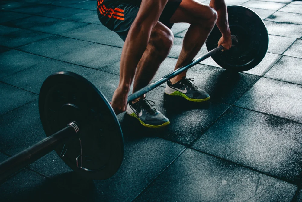 Barra con discos apoyada en el suelo de un gimnasio
