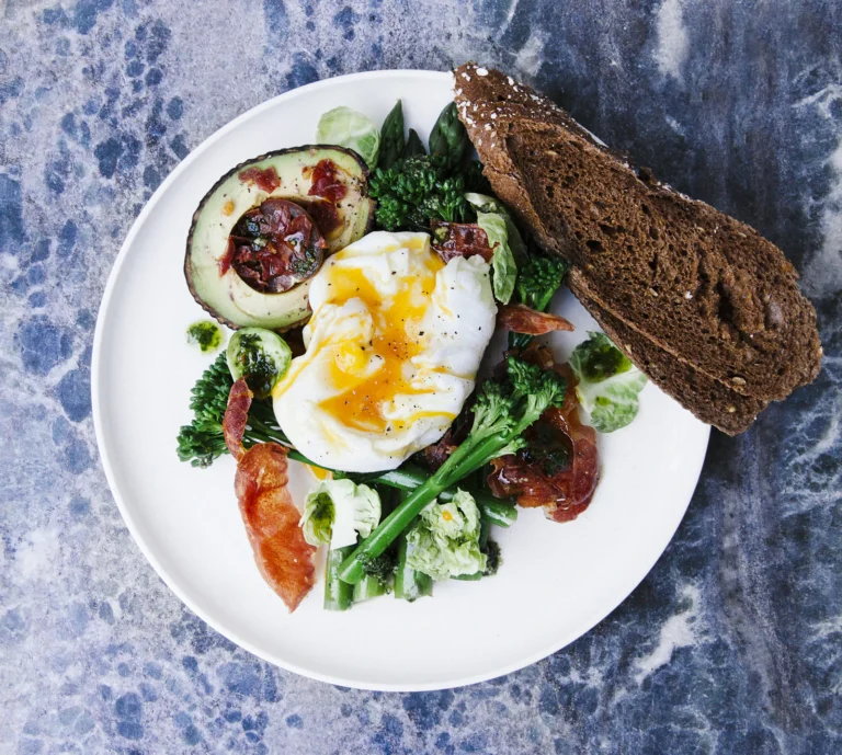 Ensalada con huevo escalfado, aguacate y tomates cherry en un plato