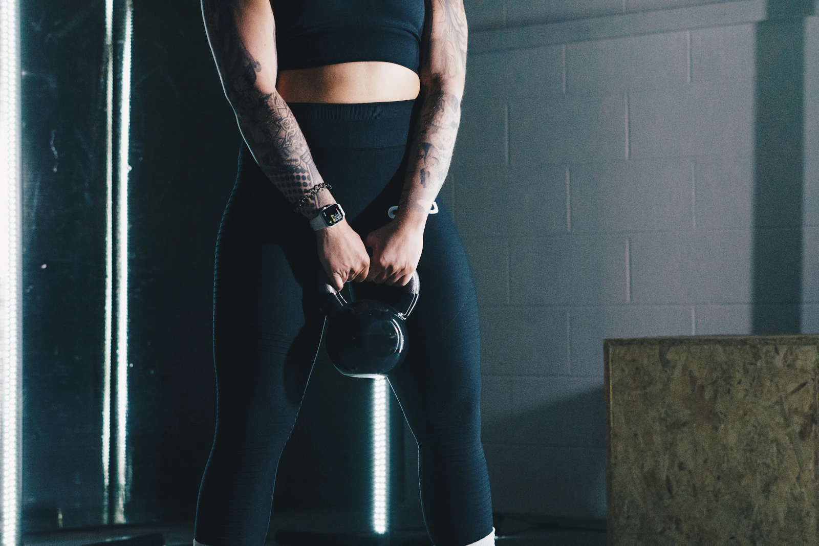 Deportista haciendo un peso muerto a una pierna con una kettlebell en la mano