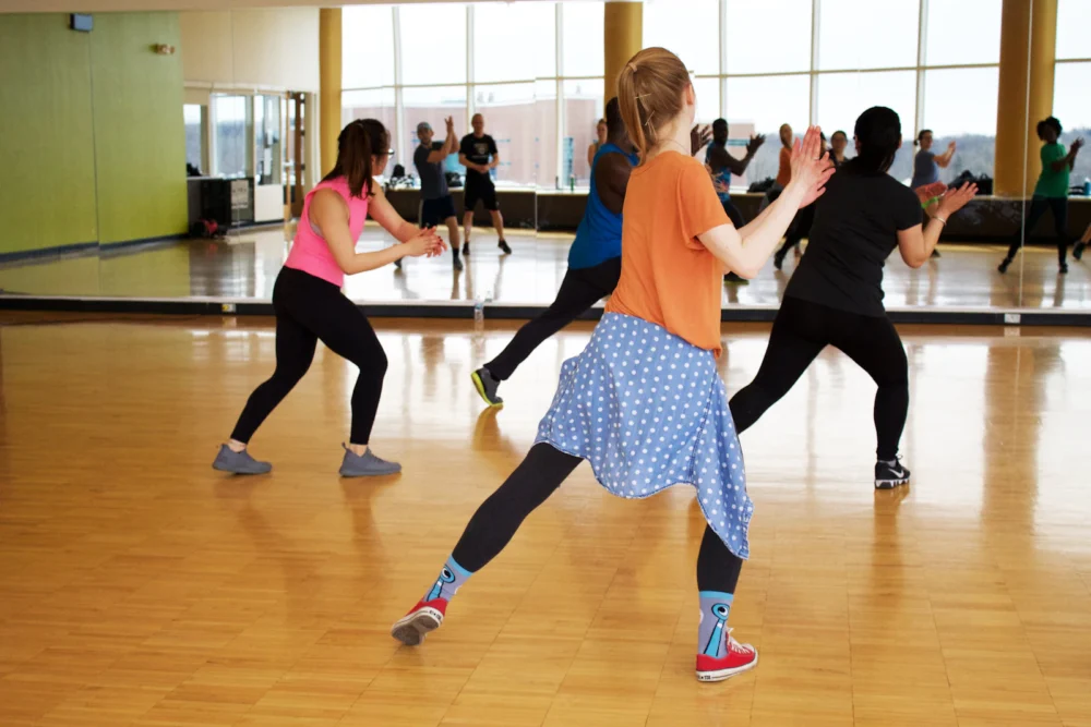 Clase de barre con alumnas apoyadas en la barra