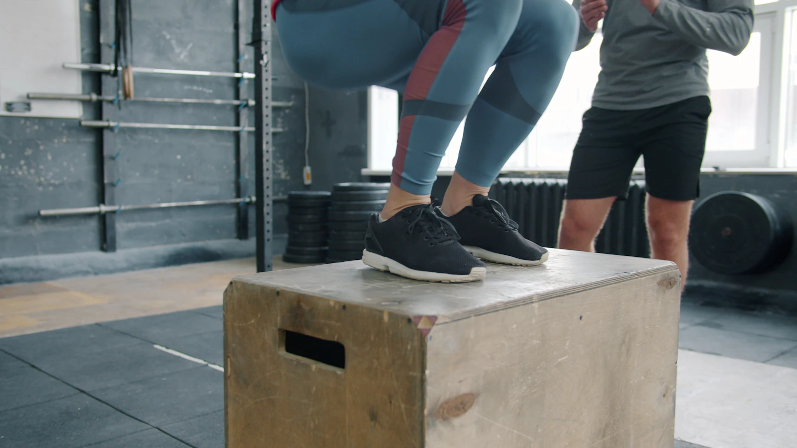 Persona saltando sobre un cajón pliométrico en un gimnasio