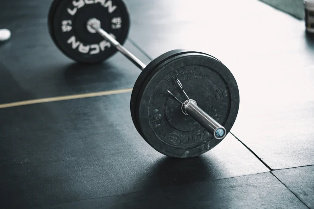 Persona levantando una barra con discos en un gimnasio