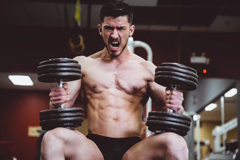 Persona haciendo una sentadilla goblet con una mancuerna en un gimnasio
