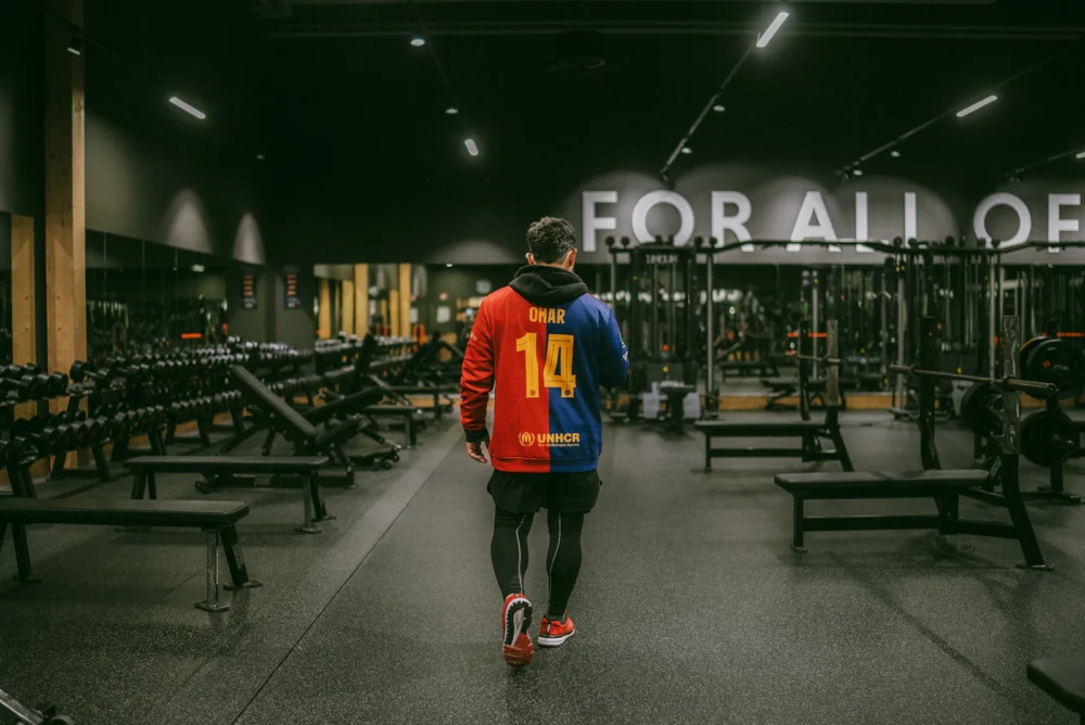 Persona haciendo press de banca con barra en un gimnasio